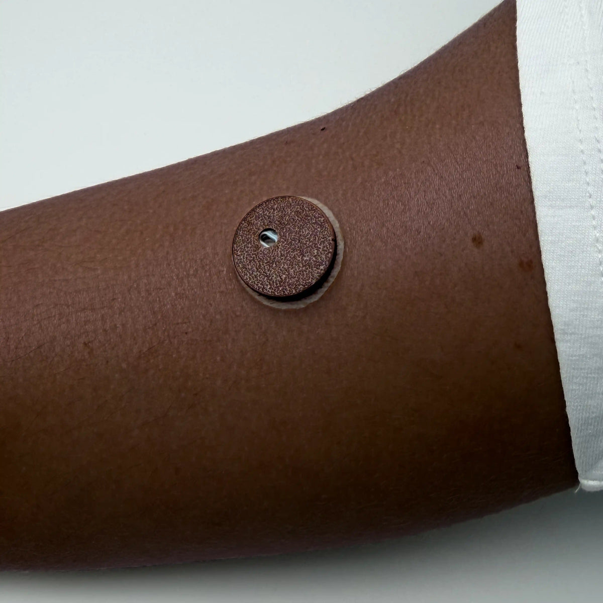 Coque marron ébène posée sur un capteur FreeStyle Libre 3, portée au bras